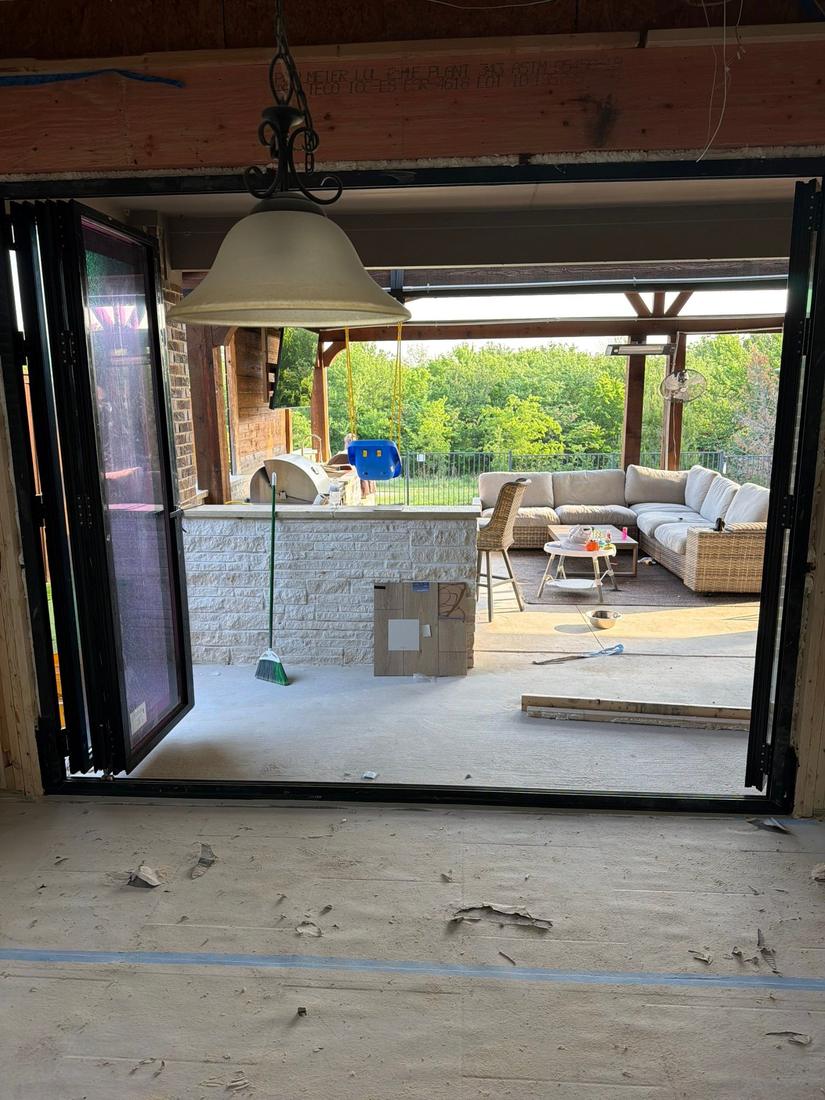 Bifold door panels folded fully open to covered patio and outdoor kitchen